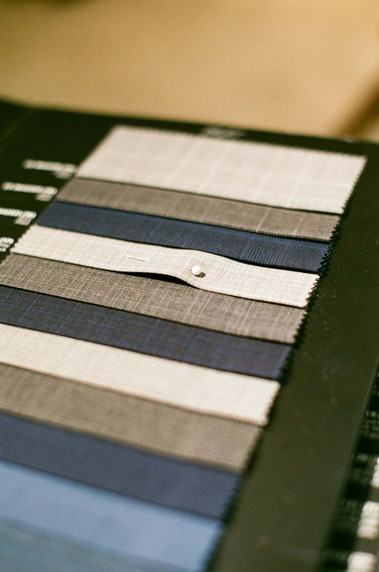 A swatch card of suiting fabrics in greys and blues